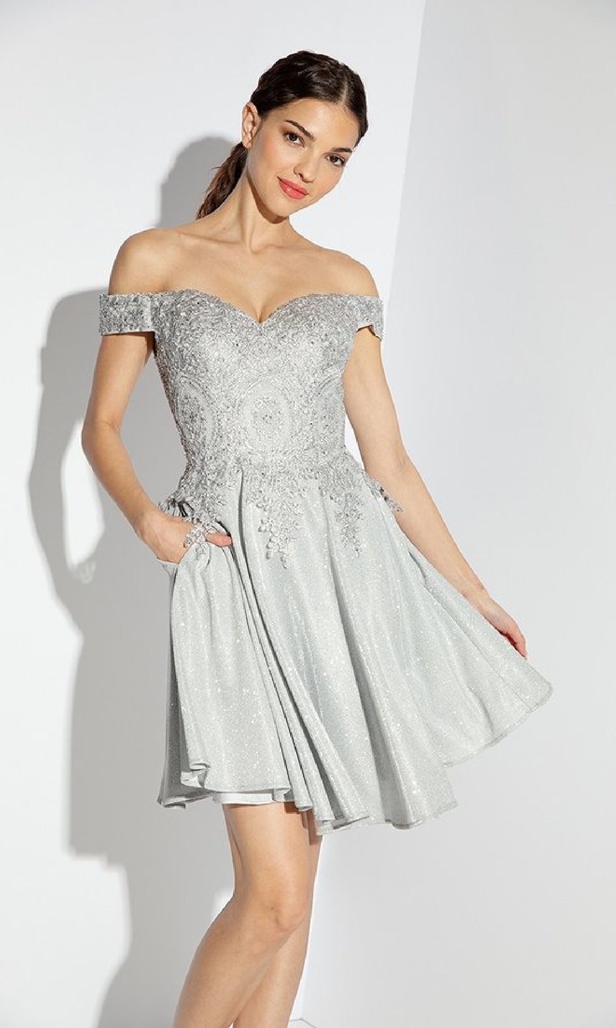 Woman in the Off-Shoulder Short Glitter Hoco Dress: Eureka 9366, featuring a light silver embroidered bodice and flared skirt—an ideal chic choice for homecoming or as a short cocktail dress.